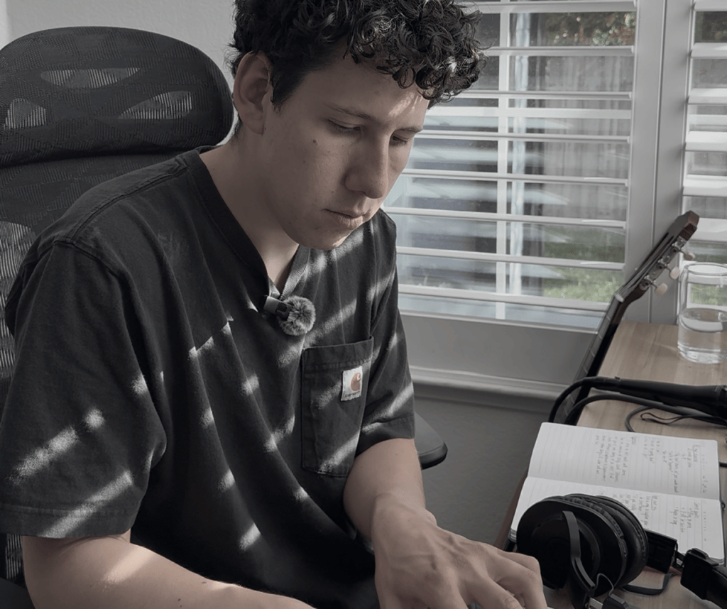 Ryan Cole Rodriquez playing a MIDI keyboard in his home studio during an experiment comparing four ways of making music with AI.